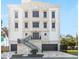 Stately three-story residence featuring a stone facade, dual garages, and attractive landscaping at 3087 Cherry Ln, Clearwater, FL 33759