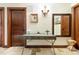 Hallway features travertine tile, warm lighting, rustic wood doors, and a unique metal table at 3087 Cherry Ln, Clearwater, FL 33759