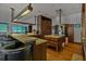 Modern kitchen featuring wood cabinetry, stainless steel appliances, bar seating, and integrated beach themed screens at 3087 Cherry Ln, Clearwater, FL 33759
