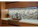 Modern kitchen sink features a unique backsplash and stylish fixtures under ambient lighting at 3087 Cherry Ln, Clearwater, FL 33759