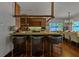 Kitchen featuring modern bar stools, island seating, and views of the dining area at 3087 Cherry Ln, Clearwater, FL 33759