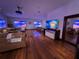 Living room with a projector screen, multiple seating areas, and hard wood floors at 3087 Cherry Ln, Clearwater, FL 33759