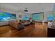 Large living room featuring a projector screen, multiple televisions, hardwood floors and comfortable seating at 3087 Cherry Ln, Clearwater, FL 33759