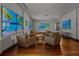 Spacious living room with comfortable seating, hardwood floors, and an array of screens displaying tropical beach scenes at 3087 Cherry Ln, Clearwater, FL 33759