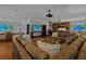 Expansive living area showcasing an open floor plan, large sectional sofa, bar seating, and striking beach scene displays at 3087 Cherry Ln, Clearwater, FL 33759
