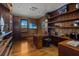 Spacious office with hardwood floors, custom built-in shelves, modern furniture, and beach scenery on television at 3087 Cherry Ln, Clearwater, FL 33759