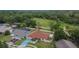 Aerial showing a house with a private pool in the backyard, next to a green park with mature trees in a neighborhood at 3092 Hillside Ln, Safety Harbor, FL 34695