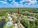Aerial view of condo community with pool, lake, tennis courts, and parking at 3188 Lake Pine S Way # B1, Tarpon Springs, FL 34688