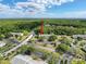 Aerial view of condo buildings nestled among lush greenery, complete with a tennis court and ample parking at 3188 Lake Pine S Way # B1, Tarpon Springs, FL 34688
