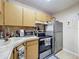 Kitchen with stainless steel appliances, light wood cabinets, and modern fixtures at 3188 Lake Pine S Way # B1, Tarpon Springs, FL 34688