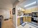 Kitchen featuring light wood cabinets, stainless steel appliances, and open layout to the dining and living area at 3188 Lake Pine S Way # B1, Tarpon Springs, FL 34688