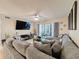 Inviting living room showcasing a plush sectional, flat-screen TV, and sliding doors to a screened balcony at 3188 Lake Pine S Way # B1, Tarpon Springs, FL 34688