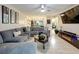 Spacious living room featuring a comfortable gray sectional couch and modern decor with an adjacent dining area at 3188 Lake Pine S Way # B1, Tarpon Springs, FL 34688