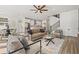 Bright open-concept living room with a ceiling fan, modern furnishings and open access to the kitchen at 3505 N Dartmouth Ave, Tampa, FL 33603