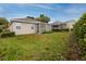 Well-maintained backyard with lush green lawn, screened-in porch, and mature landscaping at 3726 Rain Tree Ct, Palm Harbor, FL 34685