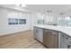 Open-concept kitchen featuring a large island with seating and a stainless steel dishwasher at 3726 Rain Tree Ct, Palm Harbor, FL 34685