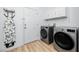 A laundry room with modern washer and dryer and a utility door at 3726 Rain Tree Ct, Palm Harbor, FL 34685