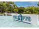 Community entrance sign for Indigo Pond, surrounded by manicured landscaping and a water feature at 3726 Rain Tree Ct, Palm Harbor, FL 34685