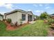 Well-manicured backyard with lush green grass, mulch beds, and colorful potted plants at 5116 Gato Del Sol Cir, Wesley Chapel, FL 33544