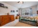 Comfortable bedroom with a ceiling fan, a warm wood dresser, and a lovely quilt-covered bed by a window at 5116 Gato Del Sol Cir, Wesley Chapel, FL 33544