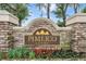 Pimlico Village community entrance sign with stone and vibrant landscaping at 5116 Gato Del Sol Cir, Wesley Chapel, FL 33544