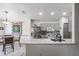 Bright kitchen features gray cabinets, stainless steel appliances, granite countertop, and bar stool seating at 5116 Gato Del Sol Cir, Wesley Chapel, FL 33544
