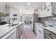 This is a bright kitchen with stainless steel appliances, gray cabinets, and an open view to the breakfast nook at 5116 Gato Del Sol Cir, Wesley Chapel, FL 33544