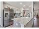 The bright kitchen features stainless steel appliances, gray cabinets, and a breakfast bar with granite countertop at 5116 Gato Del Sol Cir, Wesley Chapel, FL 33544