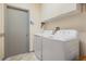 Practical laundry room with washer, dryer, storage cabinets, and a neutral color scheme at 5116 Gato Del Sol Cir, Wesley Chapel, FL 33544