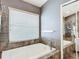 Bright bathroom featuring a soaking tub with tiled surround and window for natural light at 5526 Braddock Dr, Zephyrhills, FL 33541