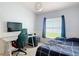 This bedroom features a desk, and a window with dark curtains and blinds at 5526 Braddock Dr, Zephyrhills, FL 33541