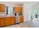 Bright kitchen featuring stainless steel appliances, oak cabinets, and tile backsplash near a glass patio door at 5526 Braddock Dr, Zephyrhills, FL 33541