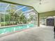 Enjoy the screened-in pool and spa area surrounded by lush landscaping at 5526 Braddock Dr, Zephyrhills, FL 33541