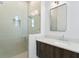 Bathroom featuring frameless glass shower and wood vanity with white countertop at 804 S Davis Blvd, Tampa, FL 33606