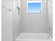 Bright bathroom featuring bathtub with white subway tile, a shower head, and a window at 804 S Davis Blvd, Tampa, FL 33606