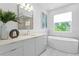 Luxurious bathroom with a soaking tub, elegant vanity, and serene garden view, creating a tranquil retreat at 804 S Davis Blvd, Tampa, FL 33606