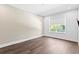 An empty bedroom featuring hardwood floors, neutral walls, and a large window at 804 S Davis Blvd, Tampa, FL 33606