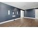 Large bedroom with hardwood floors, blue textured wallpaper, and recessed lighting at 804 S Davis Blvd, Tampa, FL 33606