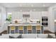 Modern kitchen featuring sleek white cabinets, a central island with seating, and stainless steel appliances at 804 S Davis Blvd, Tampa, FL 33606