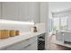 Modern kitchen featuring sleek white cabinets, a wine cooler, and a bright dining area with a view at 804 S Davis Blvd, Tampa, FL 33606