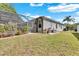 Well-maintained backyard with lush green grass, a screened-in patio, and mature landscaping at 8202 Pinewood Run Ct, Tampa, FL 33647