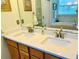 Bathroom featuring double sinks with quartz countertops and light wood cabinets at 8202 Pinewood Run Ct, Tampa, FL 33647