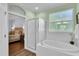 Bathroom with glass enclosed shower, soaking tub, and light green walls at 8202 Pinewood Run Ct, Tampa, FL 33647