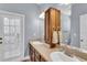 Bathroom with double sinks, a linen cabinet, and a door leading to the outside at 8202 Pinewood Run Ct, Tampa, FL 33647