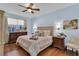 Comfortable bedroom with blue walls, wood floors, and a large window with natural light at 8202 Pinewood Run Ct, Tampa, FL 33647