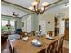 Formal dining room with wood table set for six, chandelier, and view of living area at 8202 Pinewood Run Ct, Tampa, FL 33647