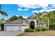 Charming single-story home features a well-manicured lawn, three-car garage, and arched entryway at 8202 Pinewood Run Ct, Tampa, FL 33647