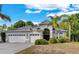 Well-maintained home with three-car garage and palm trees in landscaped front yard at 8202 Pinewood Run Ct, Tampa, FL 33647