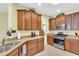 Traditional kitchen featuring wood cabinetry, granite countertops, stainless steel appliances, and tile flooring at 8202 Pinewood Run Ct, Tampa, FL 33647
