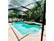 Screened pool with hot tub and waterfall feature in a brick-paved backyard oasis at 8202 Pinewood Run Ct, Tampa, FL 33647